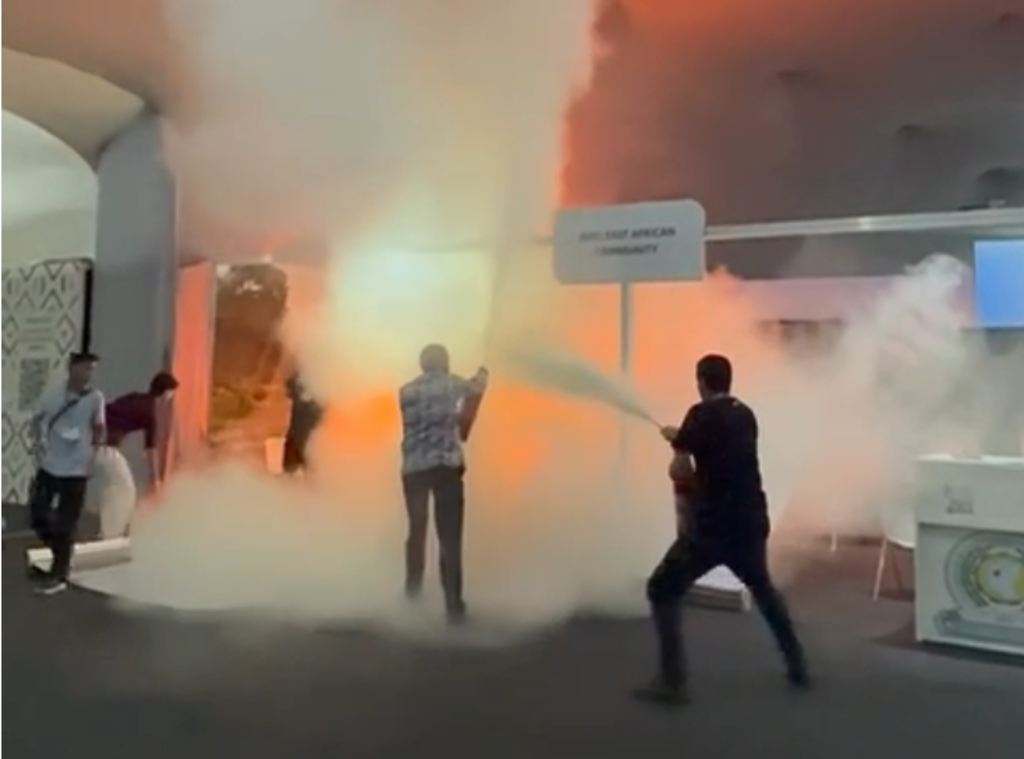 Imagem de pessoa combatendo o fogo em stand na COP30