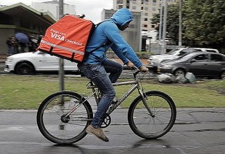 Venezuelan national Danni, who works as a bicycle courier for Colombian online delivery company "Rappi", rides his bike in Bogota, on October 11, 2018. - After meeting the challenges of Latin American economies, a group of digital companies have become a new generation of unicorns by reaching (and exceeding) the value of 1,000 million dollars, a dream of thousands of start-ups in the region. (Photo by John VIZCAINO / AFP)