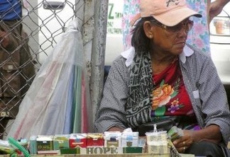 Vendedora de rua em Manila oferece maços com 20 cigarros por menos de um dólar. Foto: Kara Santos/IPS