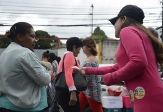 Jovem ativista entrega propaganda a uma mulher nas eleições municipais do dia 2. Foto: Tânia Rêgo/Agência Brasil