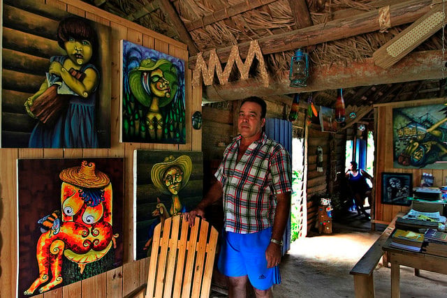 O pintor autodidata Miguel Antonio Remedios no interior de sua casa rural, transformada em galeria, estúdio e mostra de moradia tradicional, em El Abra, um lugarejo montanhoso do município de La Palma, na província de Pinar del Río, em Cuba. Foto: Jorge Luis Baños/IPS