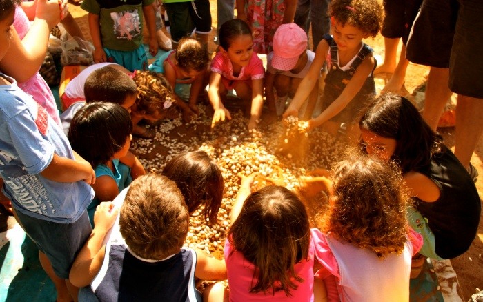 Crianças aprendendo a fazer a muvuca (mistura de sementes) na Casa das Crianças, em Canarana (MT). Foto: © Elin Romo Grande