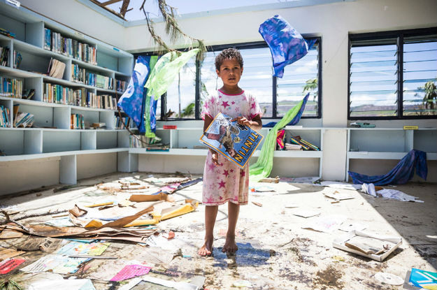 Menina de sete ano em biblioteca destruída na província de Ra, Fiji. Foto: UNICEF/UN011701/Sokhin