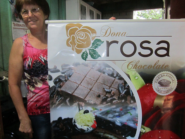 Rosalina Brighanti, conhecida como Dona Rosa, em sua cozinha, onde prepara doces, com o cartaz dos chocolates orgânicos, feitos sob padrões especiais da família, reconhecidos por consumidores e comerciantes no Brasil e no exterior. Foto: Mario Osava/ IPS