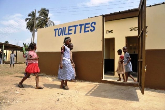Meninas e meninos visitam os novos banheiros melhorados em sua comunidade, um dos “projetos de rápido impacto” da Operação das Nações Unidas na Costa do Marfim (Onuci), que apoiou a recuperação de escolas e sanitários em Abidjan. Foto Patricia Esteve/ONU