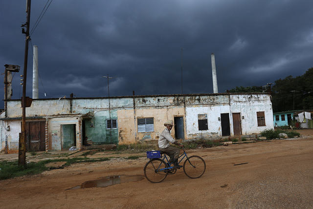 Um homem passa de bicicleta por áreas deterioradas do antigo Engenho Central Açucareiro Pablo Noriega, no povoado de Consejo Popular Pablo Noriega, 50 quilômetros ao sul de Havana, em Cuba. Foto: Jorge Luis Baños/IPS