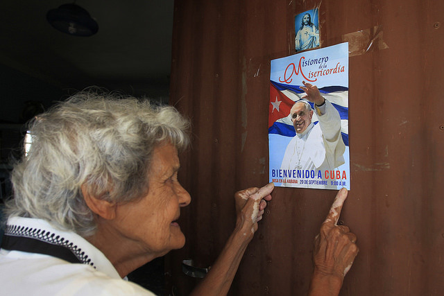 Pastora Rodríguez coloca na porta de sua humilde casa um cartaz de boas-vindas ao papa Francisco, no assentamento rural de Consejo Popular Pablo Noriega, 50 quilômetros ao sul de Havana, em Cuba. Foto: Jorge Luis Baños/IPS