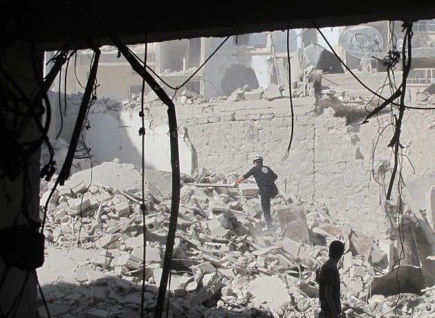 Membro da equipe de defesa civil da cidade síriade Alepo busca sobreviventes, após o ataque aéreo com uma bomba de barril, em agosto de 2014. Foto: Shelly Kittleson/IPS