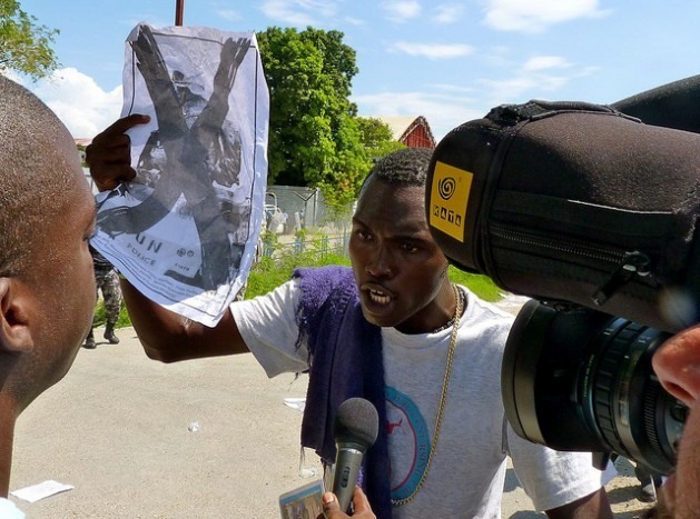 Manifestante segura um cartaz contra a ONU durante um protesto em frente à base da organização em Porto Príncipe, no Haiti. Foto: AnselHerz/IPS