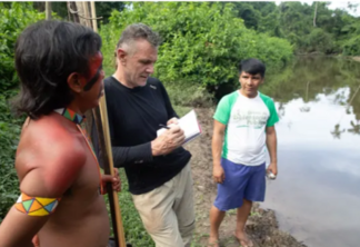 Dom Phillips conversa com dois indígenas na Aldeia Maloca Papiú, Roraima, Brasil, em 2019. Foto: João Laet/AFP/Getty Images