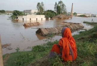 Uma mulher observa impotente como a água inunda sua cabana com teto de palha e todas as suas posses nos arredores da cidade de Bhubaneswar, no Estado de Odisha, na Índia, em 2008. Foto: Manipadma Jena/IPS