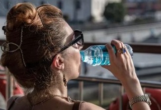 Mulher bebe água em Istambul, na Turquia, sob calor de 40°C em julho deste ano
